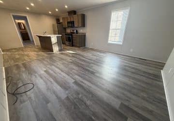 A kitchen and living room with hardwood floors.