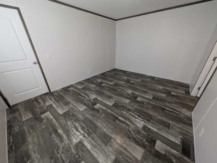 A room with a wood floor and a door.