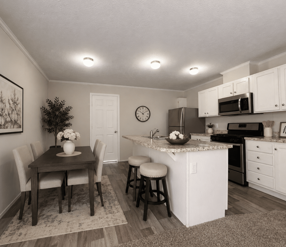 Modern kitchen and dining area with white cabinets, stainless steel appliances, a dining table for four with flowers, a kitchen island with two stools, wall art, a clock, and neutral-toned decor.